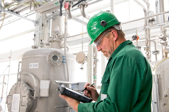 Industries - Les données d’usine capturent un homme portant un casque vert à l’aide d’une tablette