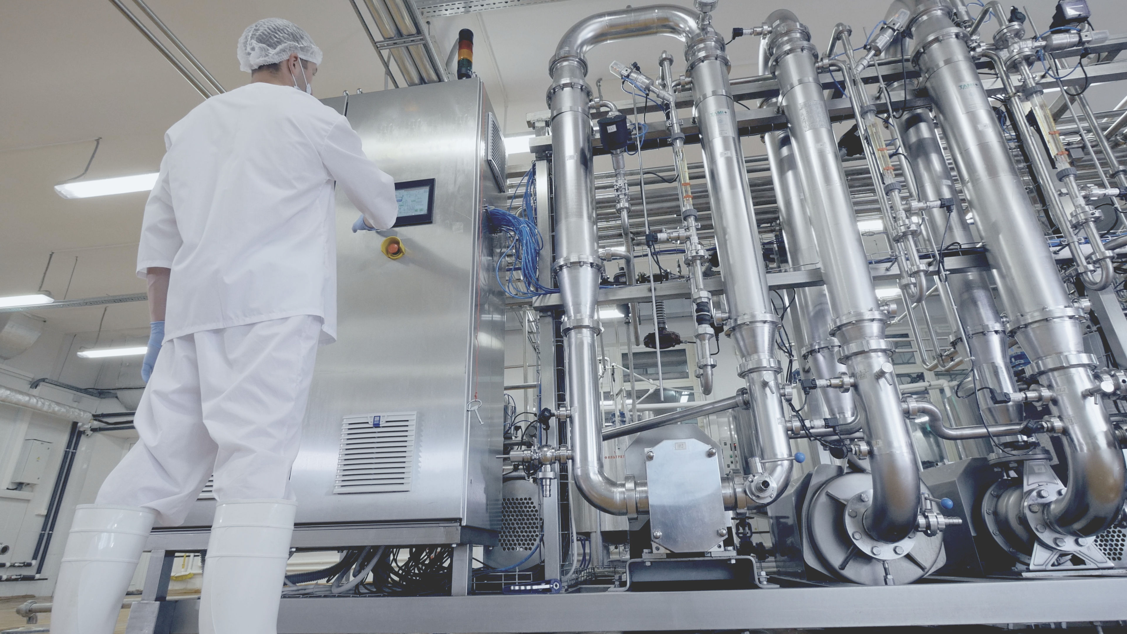 Touch screens bilang isang User Interface sa Food Processing Industry isang lalaki sa isang puting balabal at puting guwantes na nagtatrabaho sa isang pabrika