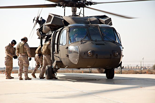 Militär - Militär en grupp människor som går bredvid en helikopter